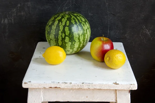 Арбуз, яблоко и лимон на белом сиденье — стоковое фото