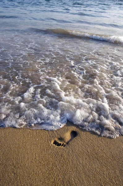 Μοναχικό βήμα επάνω στη θάλασσα άμμο παραλιών και το κύμα — Φωτογραφία Αρχείου