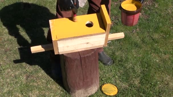 Paint in yellow new bird house nesting-box — Stock Video