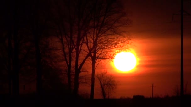 Nascente do sol perto da estrada e silhueta do carro — Vídeo de Stock