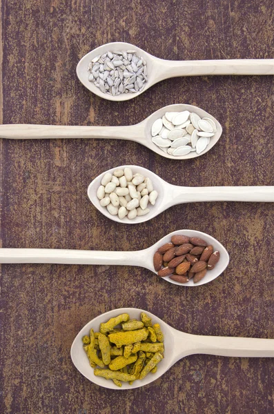 Food and spice ingredients in wooden spoons — Stock Photo, Image