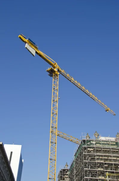 Grúa de construcción amarilla y construcción de casas en la ciudad —  Fotos de Stock