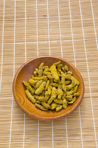 Turmeric (Curcuma longa) dry roots in wooden plate — Stock Photo, Image