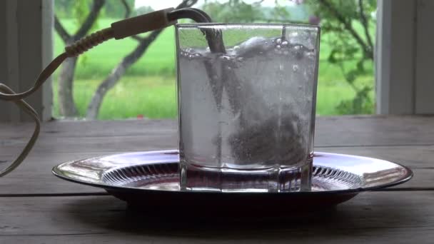 Boiling water  with  vintage heating coil tool in glass jar — Stock Video