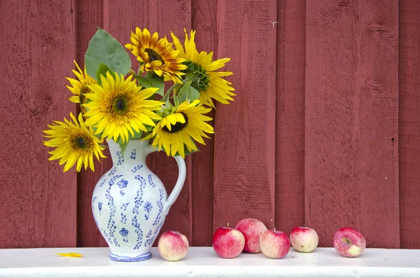 Декоративный керамический кувшин с подсолнухами и яблоками — стоковое фото
