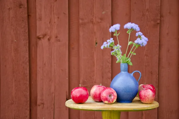 Summer apple fruits and blue vase with flowers — Stock Photo, Image