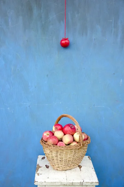 Ψάθινο ξύλινο καλάθι με κόκκινα μήλα στο κάθισμα — Φωτογραφία Αρχείου