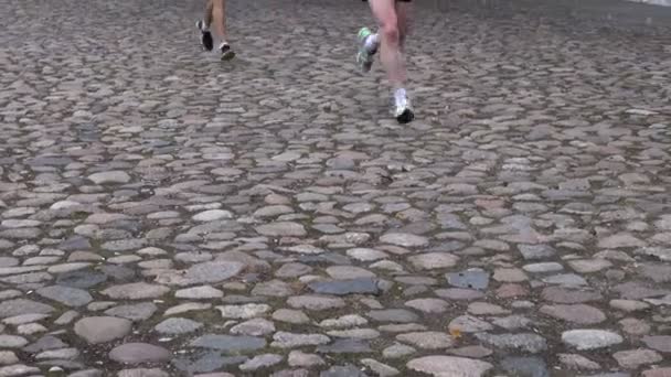 Running race people competing. feet on cobblestone road — Stock Video