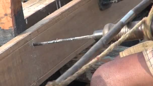 Master med primitiva verktyg borrning träbåt nära Ganges, Varanasi — Stockvideo