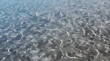 Buz sörfçüsü kış buzunda yelken açıyor, hava manzaralı.
