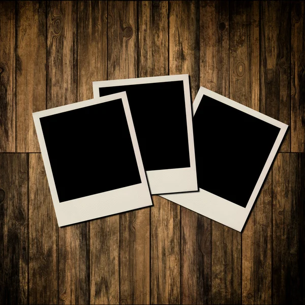 Blank instant photo frames on old wooden background — Stock Photo, Image