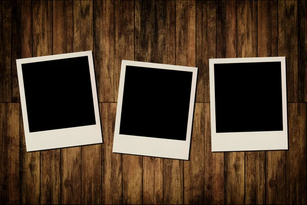 Blank instant photo frames on old wooden background — Stock Photo, Image