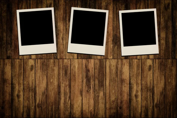 Blank instant photo frames on old wooden background — Stock Photo, Image