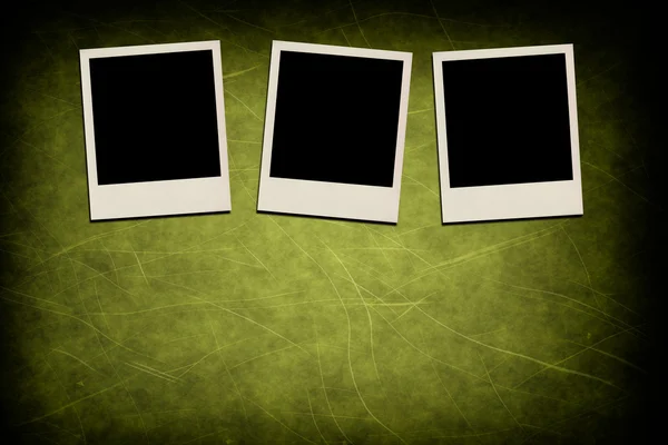 Blank instant photo frames on grunge green background — Stock Photo, Image