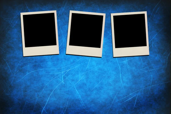 Blank instant photo frames on grunge blue background — Stock Photo, Image