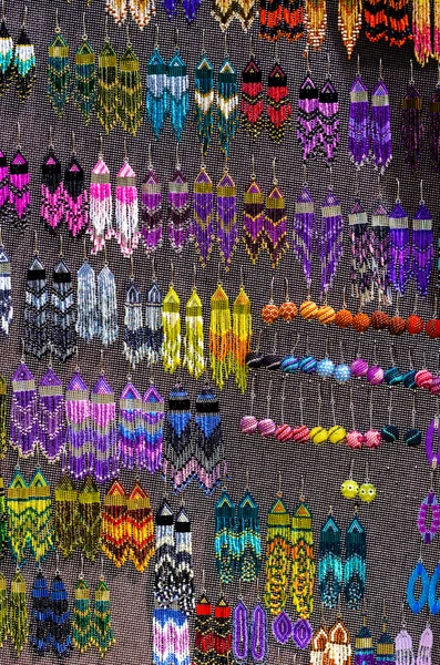 Barevné ručně vyráběné náušnice na stánku v tržnici — Stock fotografie