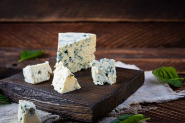 Ahşap arka planda dilimlenmiş mavi peynir. Kesme tahtasında leziz bir dorblue.