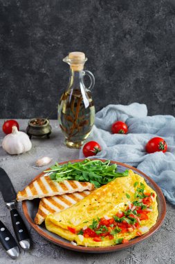 Fried omelette with tomatoes, onion and herbs. Delicious breakfast with eggs and toasts