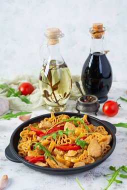 Tasty pasta in tomato sauce with chicken, pepper and herbs on white background