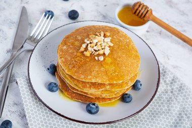 Delicious homemade pancakes with honey and blueberries. Tasty breakfast with crepes