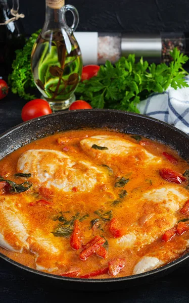 Stew chicken breast with tomato, pepper and spinach in pan