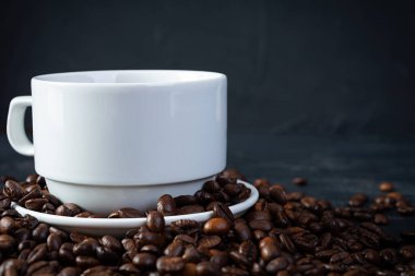 Koyu arkaplanda kahve çekirdeği olan bir fincan kahve. Bir fincan sıcak kahve.