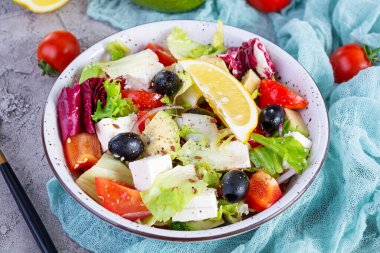 Domates, marul, avokado, zeytin, feta ve biberli taze salata. Diyet yemek.