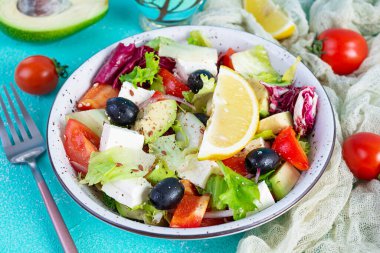 Domates, marul, avokado, zeytin, feta ve biberli taze salata. Diyet yemek.