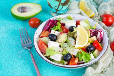 Domates, marul, avokado, zeytin, feta ve biberli taze salata. Diyet yemek.