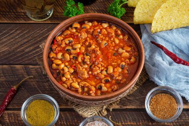 Ahşap arka planda bir kasede Chili con carne. Meksika mutfağı