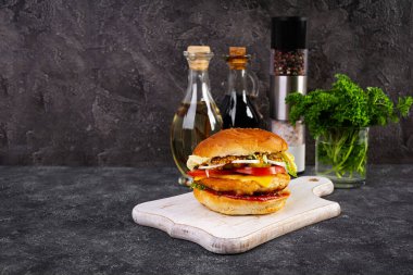 Marul, peynir, domates ve turşulu lezzetli tavuk burger. Fast food sandviç ve tavuk pirzolası.