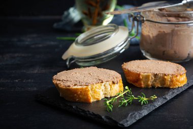 Sandwich with chicken liver pate on dark background