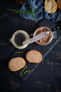 Sandwich with chicken liver pate on dark background. Top view