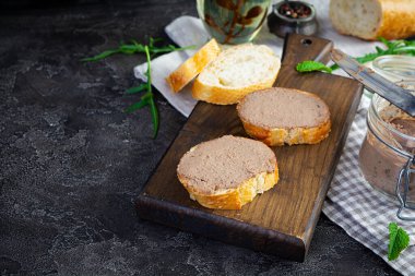 Sandwich with chicken liver pate on dark background