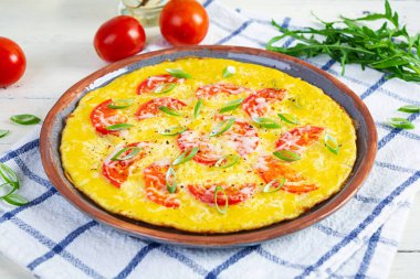 Omelette with tomatoes, herbs and grated cheese. Easy breakfast