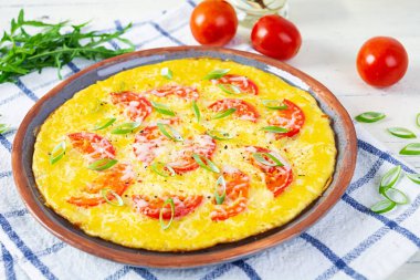 Omelette with tomatoes, herbs and grated cheese. Easy breakfast