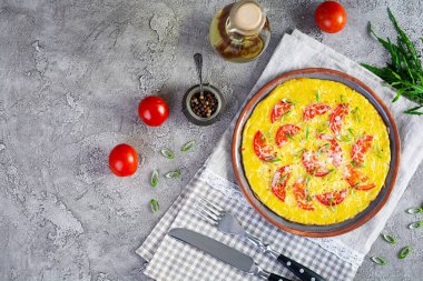 Omelette with tomatoes, herbs and grated cheese. Easy breakfast