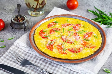 Omelette with tomatoes, herbs and grated cheese. Easy breakfast