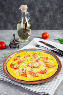 Omelette with tomatoes, herbs and grated cheese. Easy breakfast