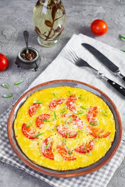 Omelette with tomatoes, herbs and grated cheese. Easy breakfast