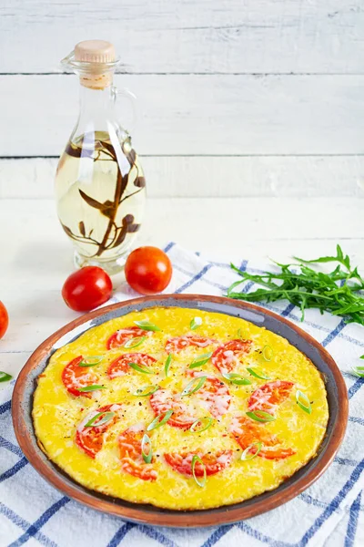 Omelette with tomatoes, herbs and grated cheese. Easy breakfast