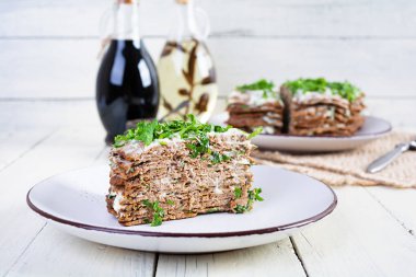 Liver cake on wooden background. Sliced layered liver cake with mayonnaise