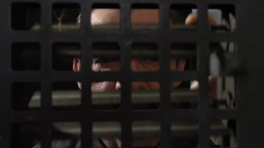 Kapalı bir kulüpteki bir güvenlik görevlisi parmaklıklı pencereden ziyaretçilere bakıyor. Metal parmaklıklı pencereler mahkumu içeriden kaçmaktan koruyor. Bazı insanları atlamak için denetleme kanalı. Hapis ve suçun ayrıntıları.