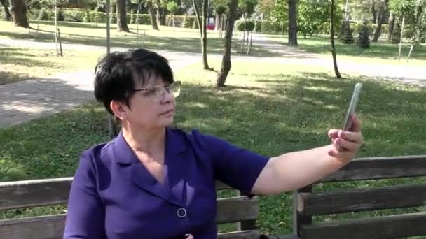 Woman Sits Bench Takes Selfie Summer Day Woman Sits Park — Vídeo de stock