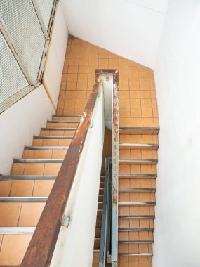 Üst kattaki beton merdiven manzarası yangın merdiveninin paslı tırabzanı ofis binasından güvenlik alanına, fotokopi alanı için ön manzara..