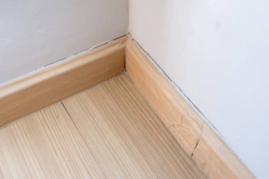 Oturma odasının köşesindeki kırık döşeme eteklerinin kapatılması, yağmurdan kaynaklanan nem nedeniyle harç söküldü. Kopyalama alanı ile ön görünüm.