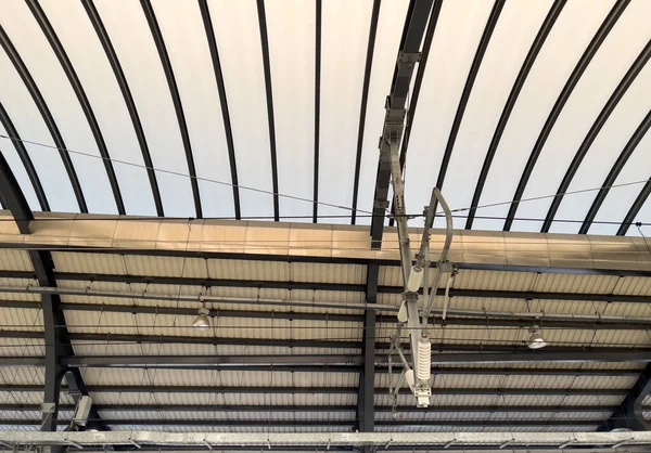 電車のエネルギー コピースペースとフロントビューのための都市駅のプラットフォームフロアの天井に架線がかかっています — ストック写真