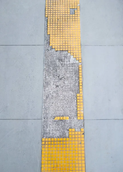 Closeup of the broken tile floor of the pedestrian near the shopping mall in the urban area, front view with the copy space.