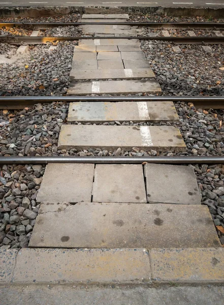 The concrete block pathway for crossing the railway track between the platform in the urban station, front view for the copy space.
