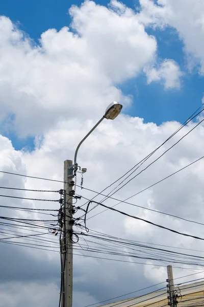 The old electric bulb on the electric pole for use in the urban village, front view with the copy space.